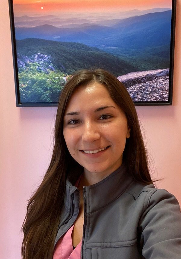 Female taking a selfie in front of a mountainside picture